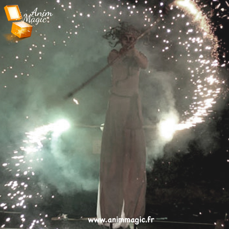 Un échassier en costume réalise une performance sur scène.