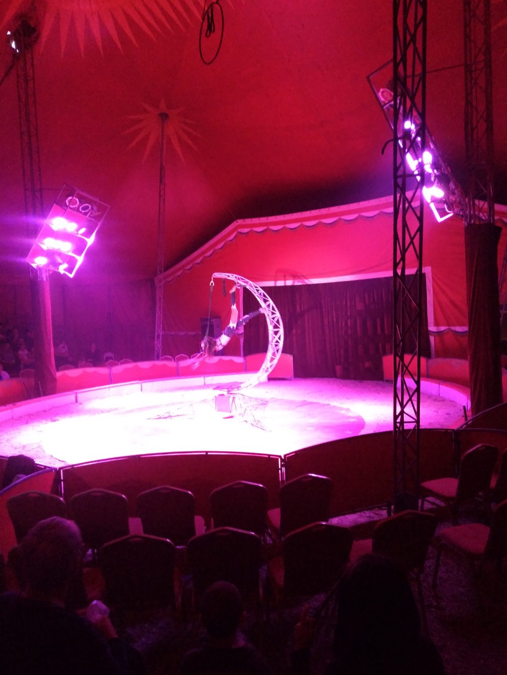 Une artiste sur scène très lumineuse étudiée par les spectateurs de Meyzieu qui se rallient à elle et aide dans son numéro exaltant et noble. Animmagic spectacle de cirque pour décembre à Lyon.